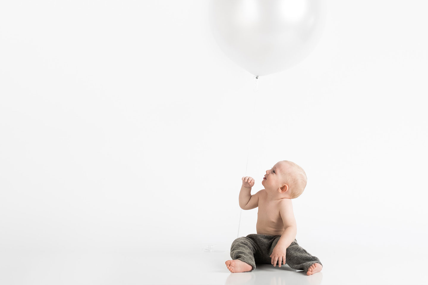 baby looking up at a baloon