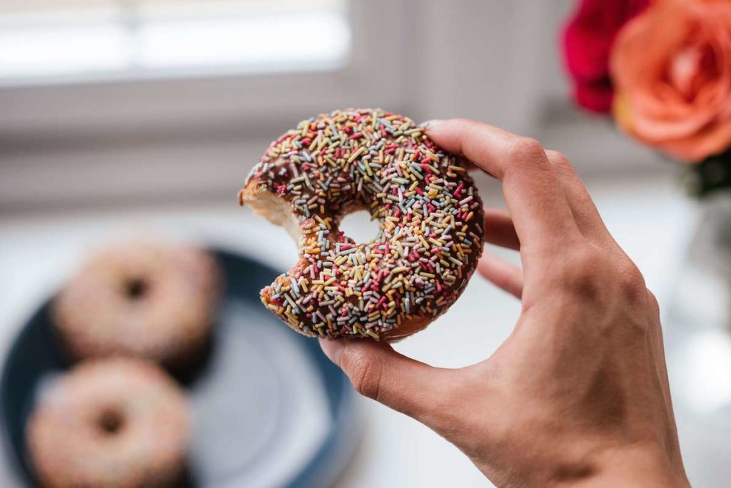 hand holding a chocolate sprinkled donut