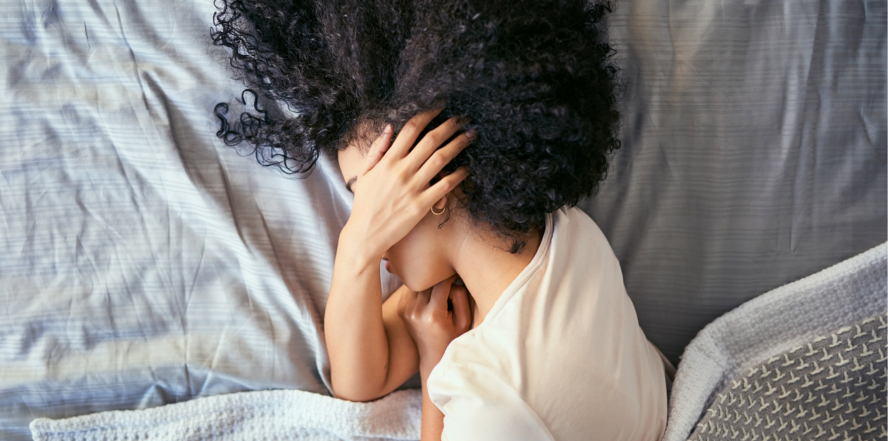 woman with migraine laying in bed
