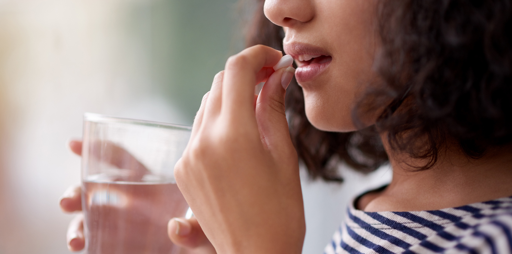 woman putting a pill in her mouth