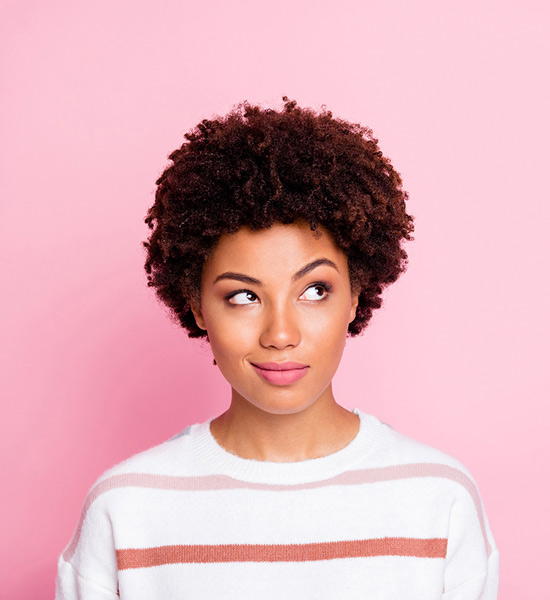 Woman smirking and raising eyebrow while looking up and away from camera