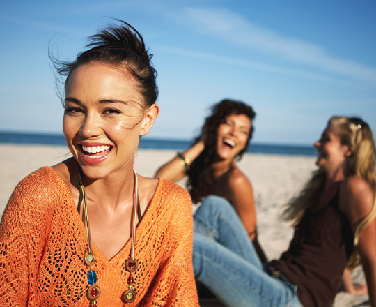 Three women laughing on the beach